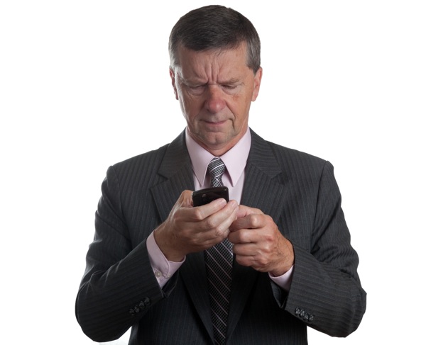 Businessman scowls at blackberry  (Steve Heap/Shutterstock)