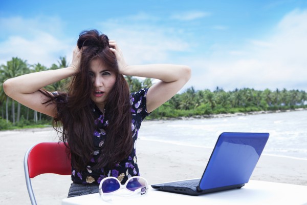 Unhappy laptop user on beach