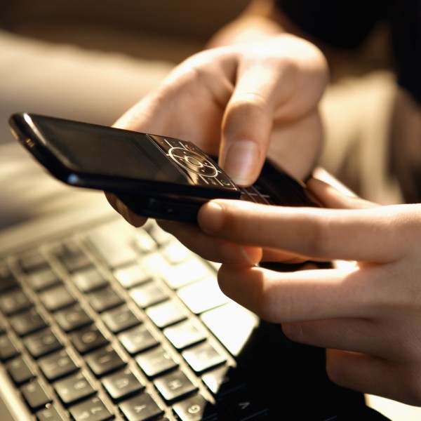 cell phone laptop keyboard fingers hands