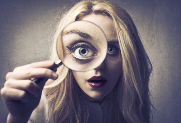 Woman looking through magnifying glass