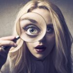 Woman looking through magnifying glass