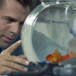 Businessman looking at goldfish in a bowl