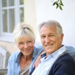 Elderly couple smiling sitting on a porch bench