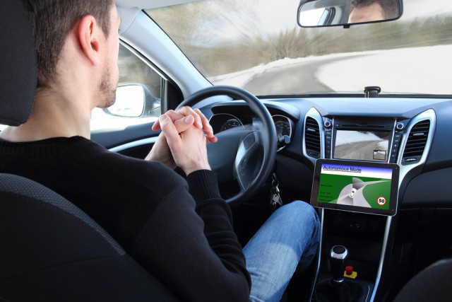 Man in a self-driving car, no hands on the steering wheel