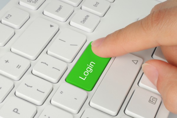 Hand pushing green login button