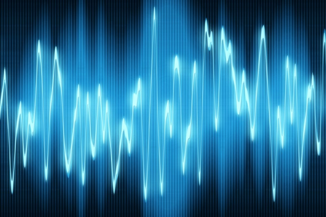 green sound waves oscillating on black background