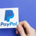 Hand holding a PayPal logo