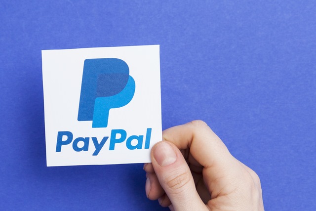 Hand holding a PayPal logo