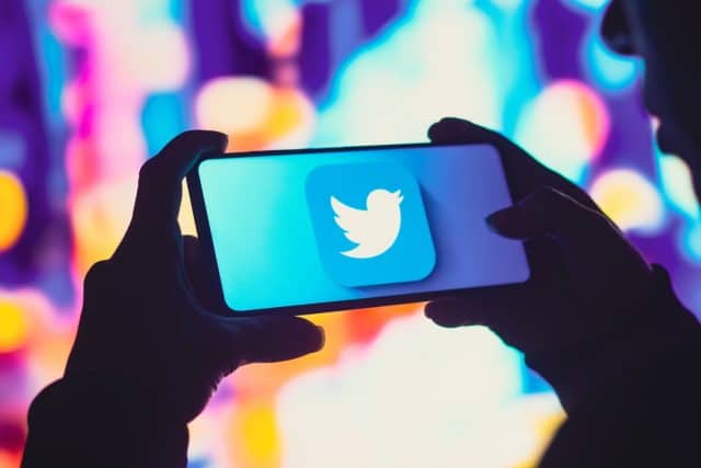 Twitter di ponsel dengan siluet orang