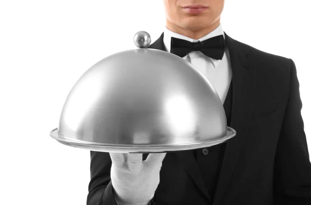 Male waiter holding cloche