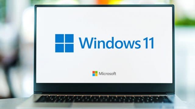 Laptop dengan logo Windows 11 dan Microsoft