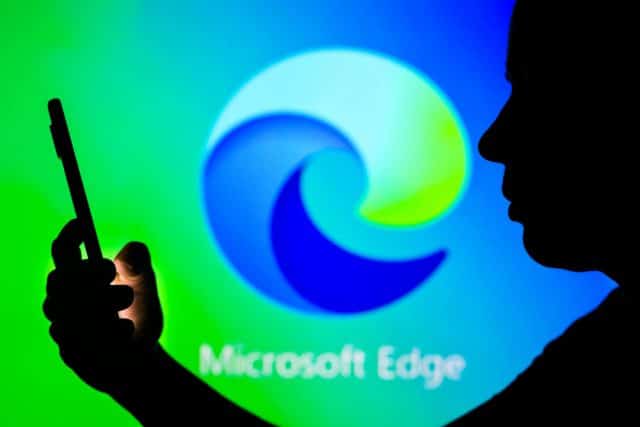 Logo Microsoft Edge buram dengan ponsel di latar depan