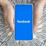 Facebook on smartphone surrounded by money