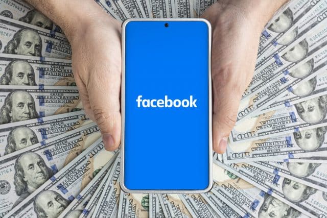 Facebook on smartphone surrounded by money
