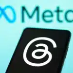 Threads logo on a mobile with blurry Meta logo in the background