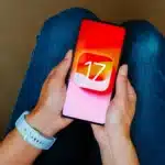 Woman holding iPhone with iOS 17 logo