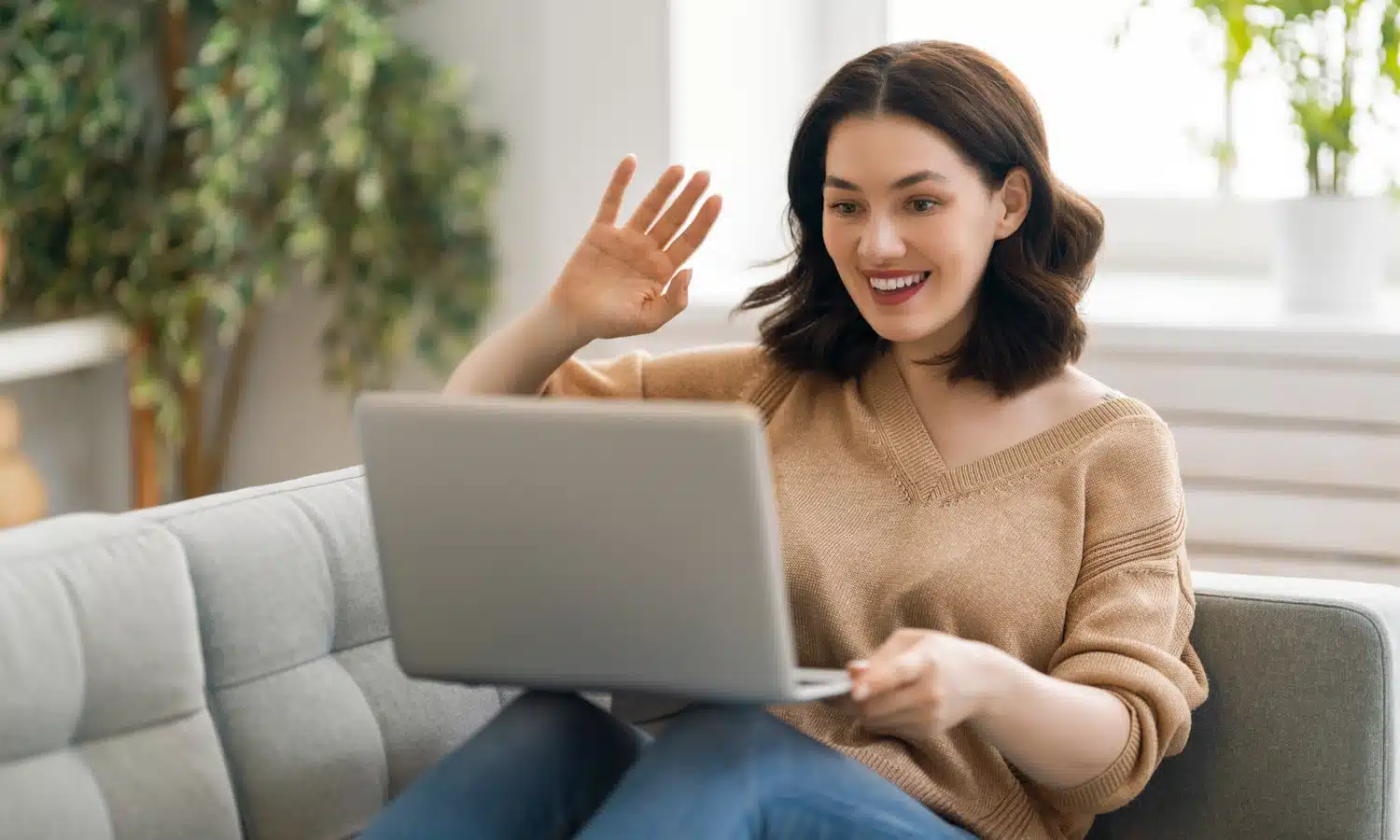 Woman waving at laptop