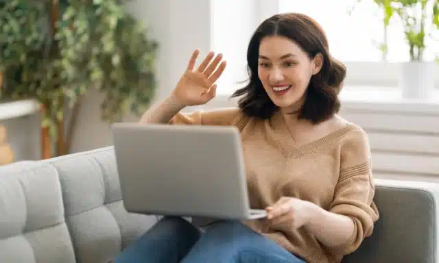 Woman waving at laptop