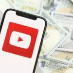 YouTube logo on phone with money in the background