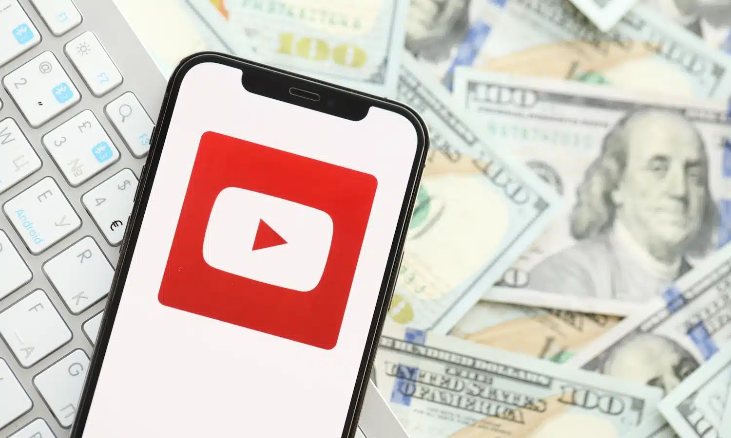 YouTube logo on phone with money in the background