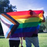 Two people holding a pride flag