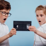 Boy and girl looking at a VHS cassette