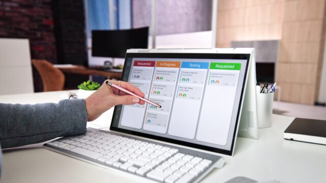 a hand holding a pen on a computer screen