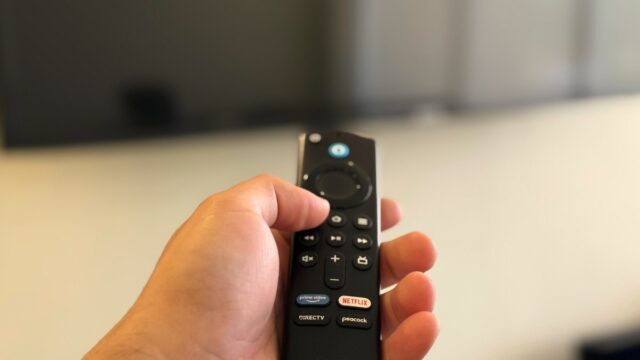 a hand holding a remote control