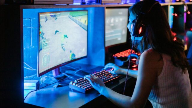 A woman playing video games wearing headphones
