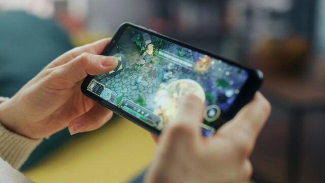 Person playing mobile game on couch