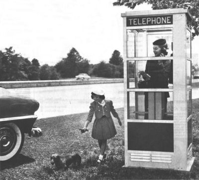 The ubiquitousness of the telephone booth in modern culture is exemplified by this exaggerated scenario: a booth on the side of the road, from an AT&T ad circa 1954.  (Courtesy phonebooth.org)