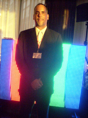 An executive from Toshiba America posing before one of his company's HD LED panels.